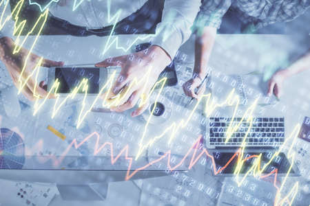 Double exposure of man and woman working together and financial chart hologram drawing. market...