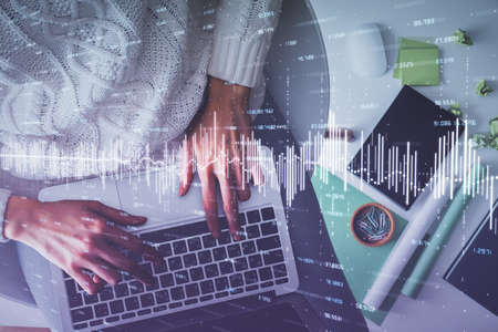 Multi exposure of woman hands working on computer and forex chart hologram drawing. Top View....