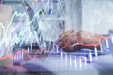 Double exposure of woman hands typing on computer and forex chart hologram drawing. Stock market...