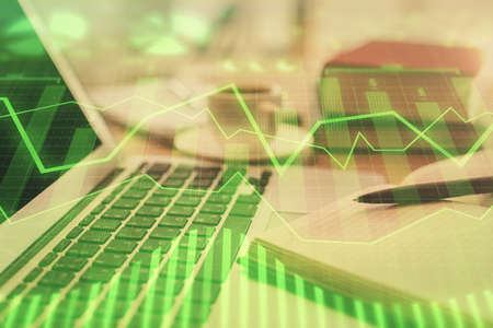 Double exposure of financial chart drawing and desktop with coffee and items on table background....