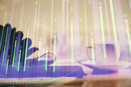 Double exposure of financial chart drawing and desktop with coffee and items on table background....