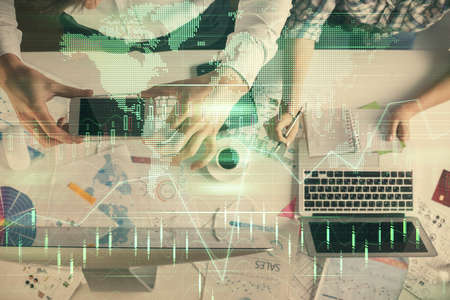 Double exposure of man and woman working together and financial chart hologram drawing. market...