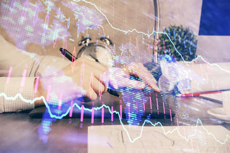 Double exposure of mans hands holding and using a phone and financial graph drawing. Analysis...
