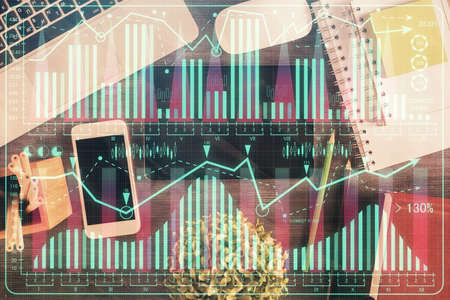 Double exposure of forex chart hologram over desktop with phone. Top view. Mobile trade platform concept.の写真素材