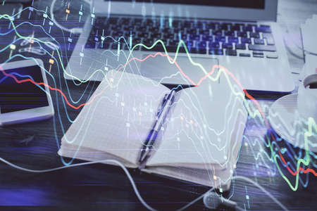 Multi exposure of financial graph drawings and desk with open notebook background. Concept of forex