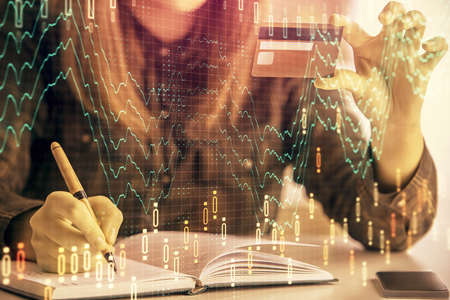 Multi exposure of woman on-line shopping holding a credit card and financial graph drawing. Stock market E-commerce concept.の写真素材
