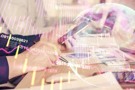 Double exposure of mans hands holding and using a digital device and forex graph drawing. Financial...