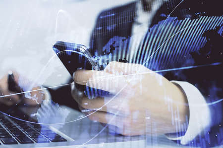 Multi exposure of mans hands holding and using a digital phone and forex graph drawing. Financial...