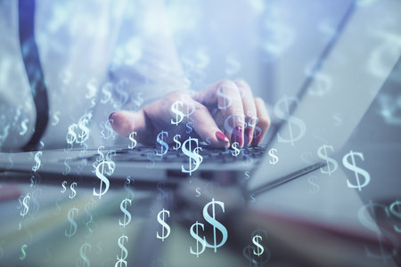 Double exposure of businesswoman hands typing on computer and financial graph hologram drawing. Stock market analysis concept.の写真素材