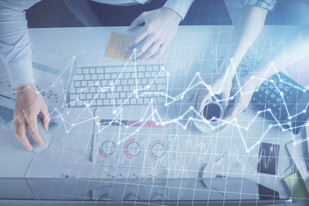 Double exposure of man and woman working together and financial chart hologram drawing. market analysis concept. Computer background. Top View.の写真素材