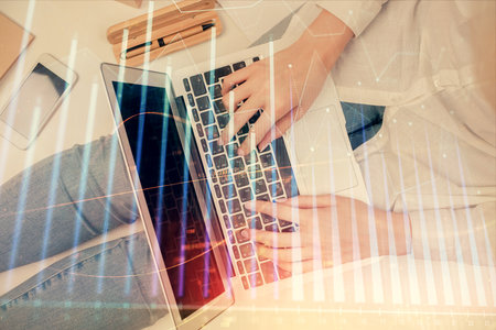 Double exposure of woman hands working on computer and forex graph hologram drawing. Top View. Financial analysis concept.の写真素材