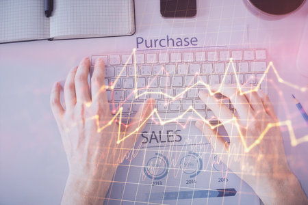 Double exposure of mans hands typing over laptop keyboard and forex chart hologram drawing. Top view. Financial markets concept.の写真素材