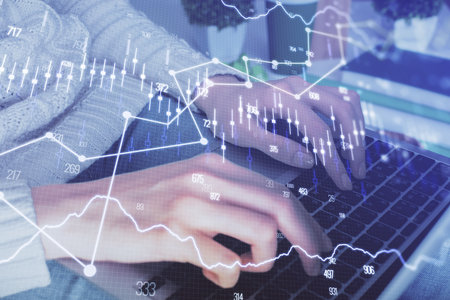 Double exposure of woman hands typing on computer and forex chart hologram drawing. Stock market...