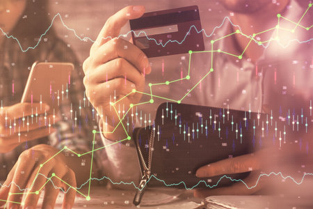 Double exposure of man and woman on-line shopping holding a credit card and forex graph hologram...