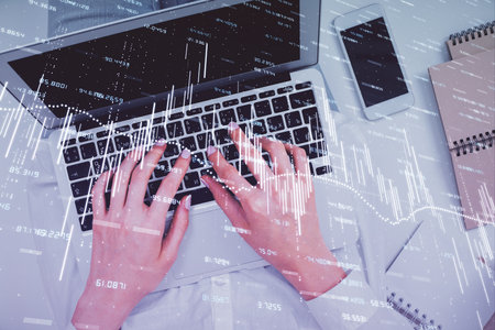 Double exposure of woman hands working on computer and forex chart hologram drawing. Top View. Financial analysis concept.の写真素材