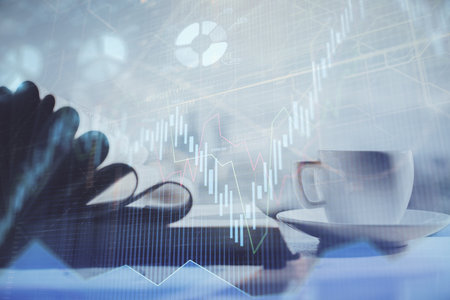 Double exposure of financial chart drawing and desktop with coffee and items on table background. Concept of forex market tradingの写真素材