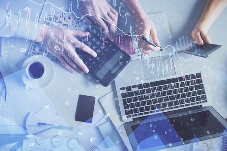 Double exposure of man and woman working together and financial chart hologram drawing. market analysis concept. Computer background. Top View.の写真素材