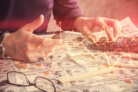 Double exposure of mans hands holding and using a digital device and forex graph drawing. Financial market concept.の写真素材