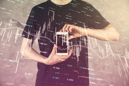 Double exposure of mans hands holding and using a digital device and forex graph drawing. Financial market concept.の写真素材