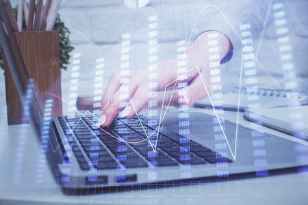 Multi exposure of woman hands typing on computer and forex chart hologram drawing. Stock market analysis concept.の写真素材