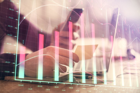 Double exposure of mans hands holding and using a phone and financial graph drawing. Analysis concept.の写真素材