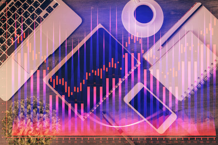 Double exposure of forex chart hologram over desktop with phone. Top view. Mobile trade platform concept.の写真素材