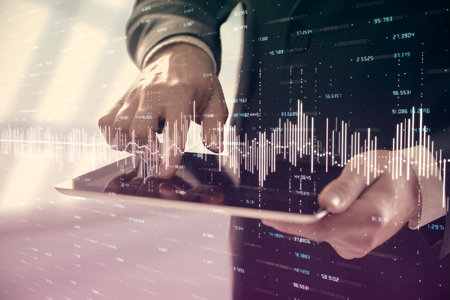 Double exposure of mans hands holding and using a digital device and forex graph drawing. Financial market concept.の写真素材