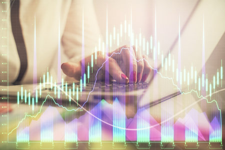 Double exposure of businesswoman hands typing on computer and financial graph hologram drawing. Stock market analysis concept.の写真素材