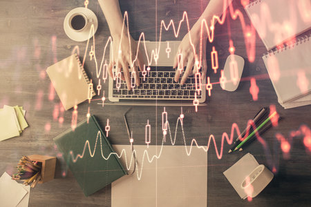 Multi exposure of woman hands working on computer and forex chart hologram drawing. Top View. Financial analysis concept.の写真素材