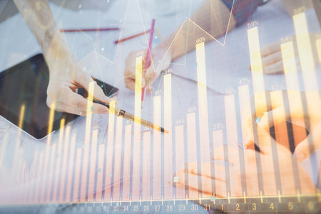 Double exposure of forex graph drawing and man and woman working together holding and using a mobile device. Trade concept.の写真素材