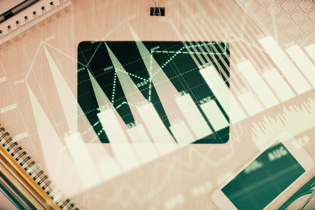 Double exposure of forex graph hologram over desktop with phone. Top view. Mobile trade platform concept.の写真素材