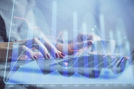 Multi exposure of woman hands typing on computer and financial graph hologram drawing. Stock market analysis concept.の写真素材
