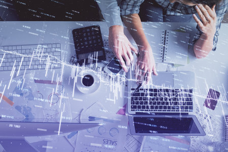Double exposure of man and woman working together and financial graph hologram drawing. market analysis concept. Computer background. Top View.の写真素材