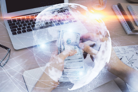 Multi exposure of financial theme drawing hologram and USA dollars bills and man hands. Business...