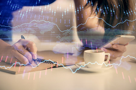 Double exposure of forex graph sketch hologram and woman holding and using a mobile device. Stock...