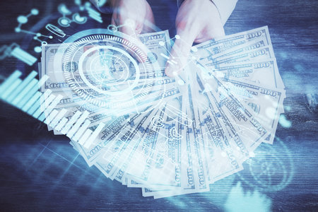 Multi exposure of financial theme drawing hologram and USA dollars bills and man hands. Business concept.の写真素材
