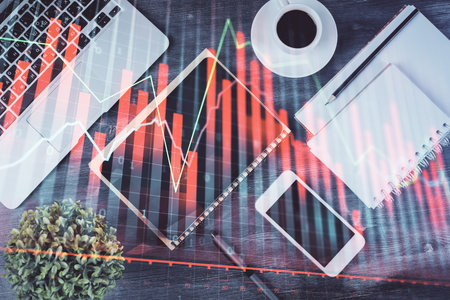 Double exposure of forex chart hologram over desktop with phone. Top view. Mobile trade platform concept.の写真素材