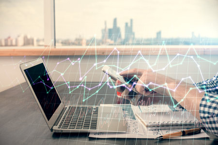 Double exposure of mans hands holding and using a digital device and forex graph drawing. Financial market concept.の写真素材