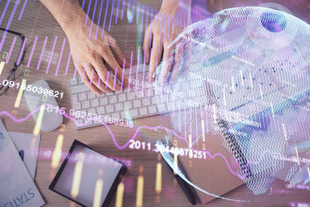 Multi exposure of mans hands typing over computer keyboard and forex graph hologram drawing. Top...
