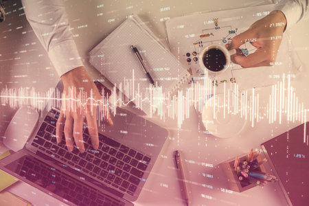 Multi exposure of mans hands typing over computer keyboard and forex graph hologram drawing. Top view. Financial markets concept.の写真素材
