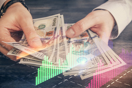 Multi exposure of financial graph drawing hologram and USA dollars bills and man hands. Analysis concept.の写真素材