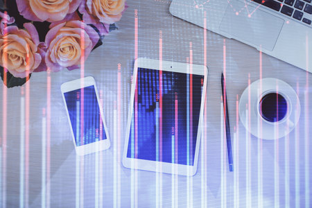 Double exposure of forex graph hologram over desktop with phone. Top view. Mobile trade platform concept.の写真素材