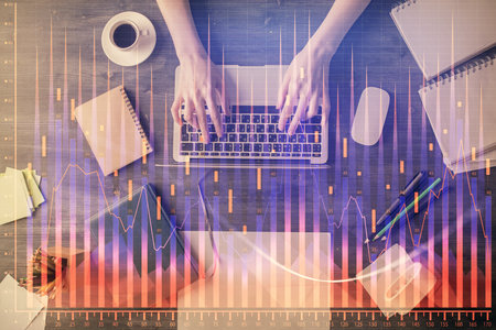 Multi exposure of woman hands working on computer and forex chart hologram drawing. Top View. Financial analysis concept.の写真素材