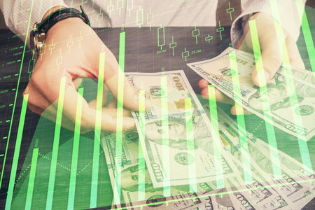Multi exposure of financial graph drawing hologram and USA dollars bills and man hands. Analysis concept.の写真素材