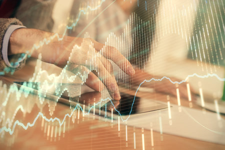 Double exposure of forex graph drawing and man and woman working together holding and using a mobile device. Trade concept.の写真素材