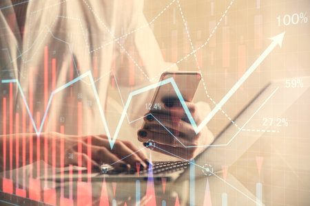 Double exposure of financial graph sketch hologram and woman holding and using a mobile device....