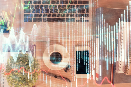 Double exposure of financial graph hologram over desktop with phone. Top view. Mobile trade platform concept.の写真素材