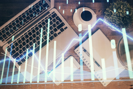 Financial market graph and top view computer on the desktop background. Double exposure. Investment concept.の写真素材