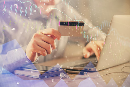 Double exposure of man hands holding a credit card and Forex graph drawing. Stock trading and...