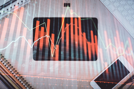 Double exposure of forex graph hologram over desktop with phone. Top view. Mobile trade platform concept.の写真素材